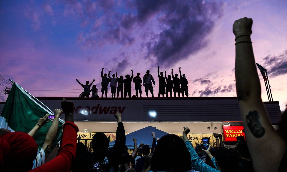 As pessoas levantam as mãos e gritam slogans enquanto protestam no memorial improvisado em homenagem a George Floyd, em 2 de junho Foto: CHANDAN KHANNA / AFP - 02/06/2020