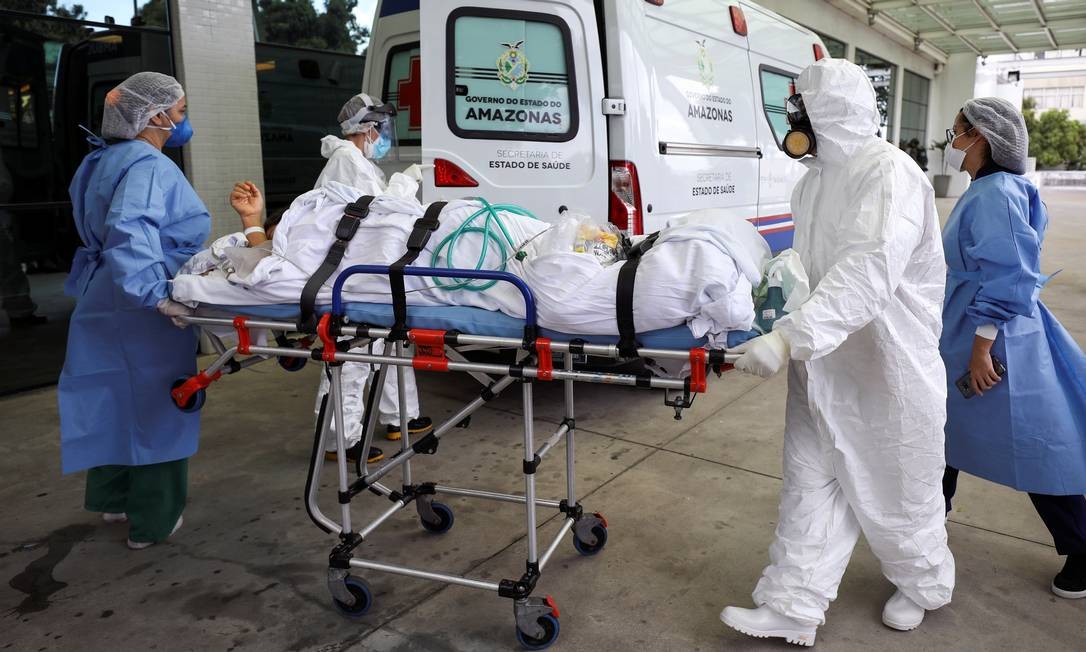 Agentes de saúde transportam paciente no hospital Getúlio Vargas, em Manaus, em meio ao novo surto de Covid-19 na capital amazonense Foto: BRUNO KELLY / REUTERS - 14/01/2021