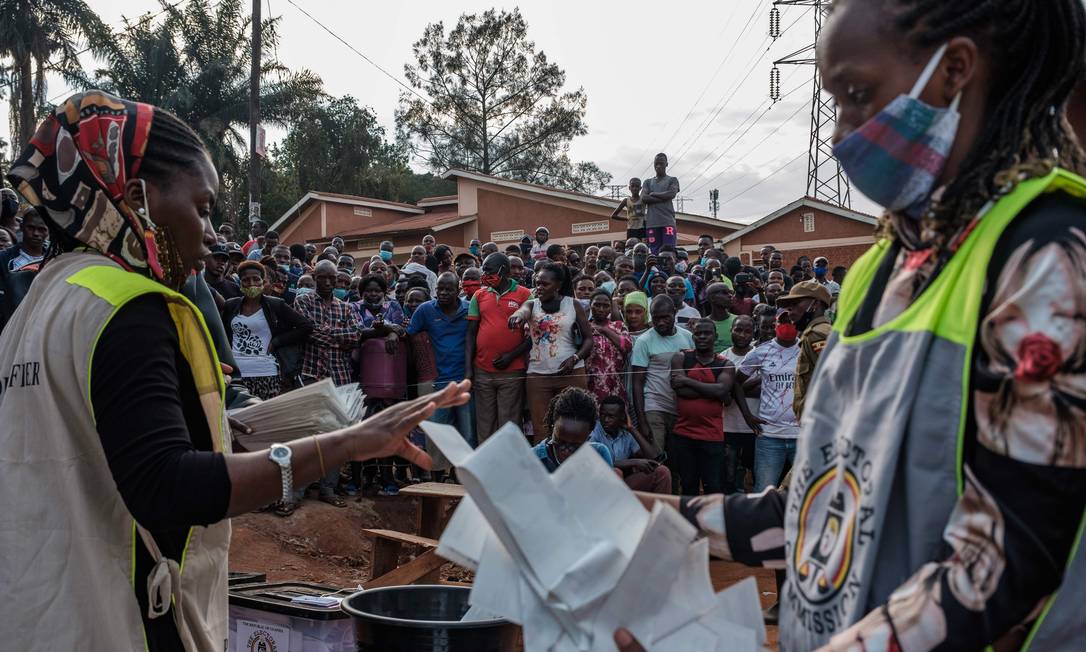 Funcionárias da Comissão Eleitoral de Uganda contam os votos que decidirão as eleições presidenciais Foto: SUMY SADURNI / AFP