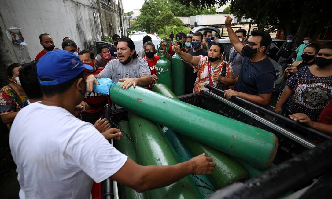 Parentes de pacientes hospitalizados ou recebendo assistência médica em casa, a diagnosticada com COVID-19, disputam para comprar oxigênio e encher botijões em uma empresa privada em Manaus Foto: BRUNO KELLY / REUTERS - - 15/01/2021