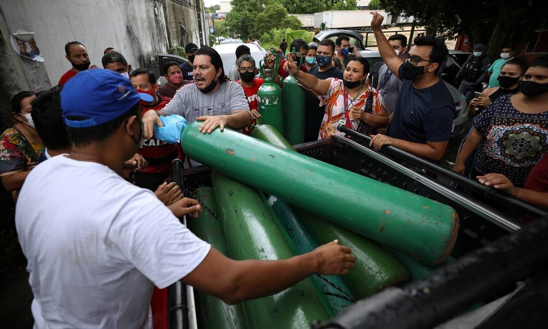 Parentes de pacientes hospitalizados ou recebendo assistência médica em casa, a maioria com COVID-19, se reúnem para comprar oxigênio e encher botijões em uma empresa privada em Manaus Foto: BRUNO KELLY / REUTERS