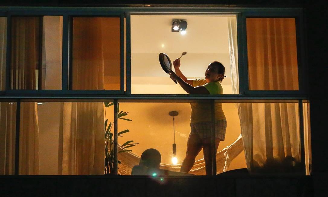 Mulher bate panelas na janela de seu apartamento, em Brasília, durante pronunciamento de Bolsonaro Bolsonaro na TV Foto: SERGIO LIMA / AFP