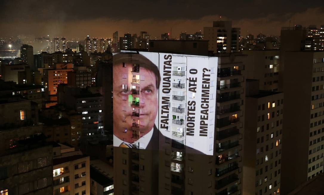 Imagem de Bolsonaro com a frase &#034;Faltam quantas mortes até o impeachment?&#034; é projetada em um prédio durante um protesto contra suas políticas para conter o coronavírus e a crise de saúde de Manaus, no bairro de Santa Cecília, em São Paulo Foto: AMANDA PEROBELLI / REUTERS