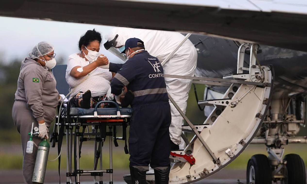Agente de saúde ajuda uma paciente com Covid-19 a embarcar em avião da Força Aérea Brasileira para ser transferida para o estado do Maranhão Foto: BRUNO KELLY / REUTERS - 15/01/2021