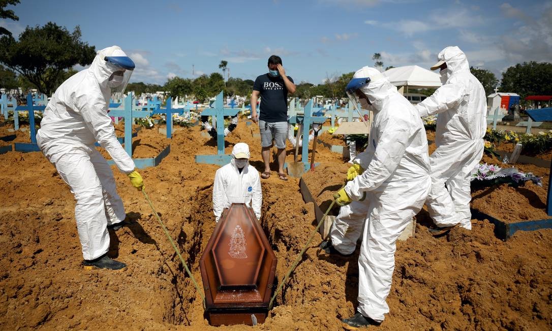 Alexandro Pinheiro Martins, 32 anos, acompanha enterro de sua irmã Elissandra Pinheiro, 39 anos, e sua sobrinha Maria Ketheleen, 22, ambas vítimas da doença, no cemitério do Parque Tarumã, em Manaus Foto: BRUNO KELLY / REUTERS