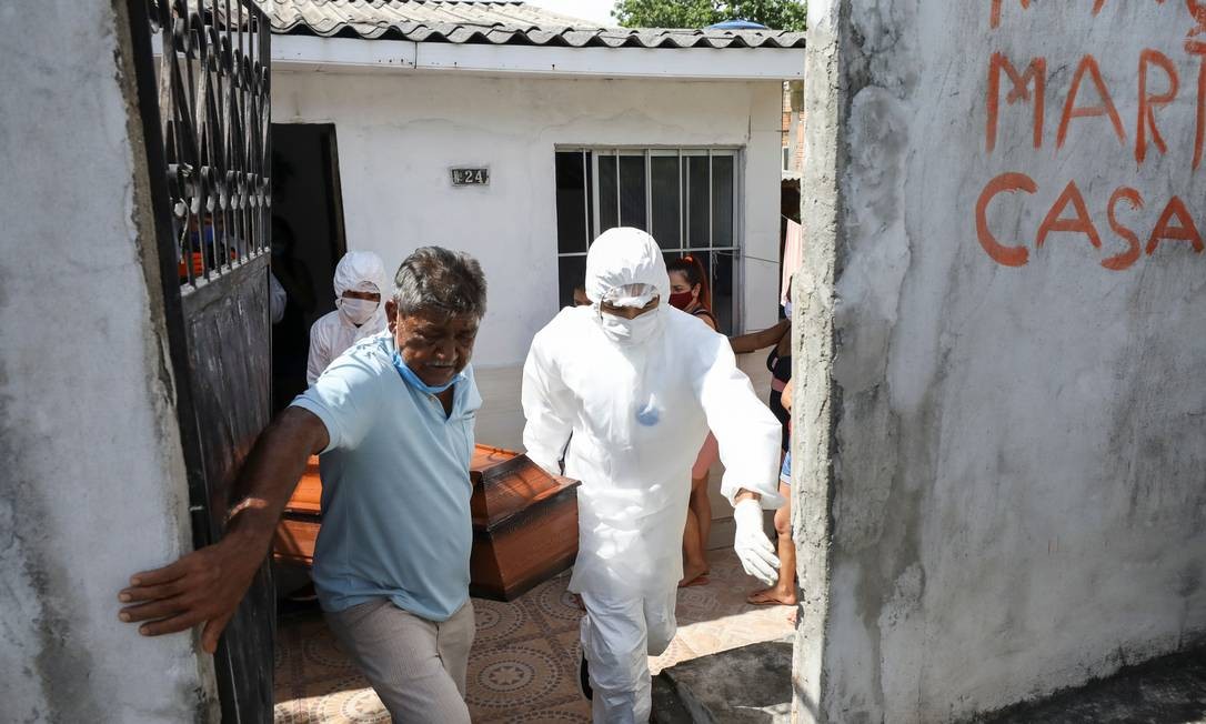 Trabalhadores do SOS Funeral retiram o corpo de Adamor Mendonça, de 75 anos, que segundo parentes morreu em casa após apresentar sintomas da Covid-19 e sem conseguir vaga nem oxigênio nos postos de saúde de Manaus Foto: BRUNO KELLY / REUTERS