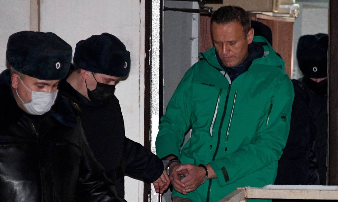 O líder da oposição, Alexei Navalny, é escoltado para fora de uma delegacia de polícia em Khimki, nos arredores de Moscou, após a decisão do tribunal que o condenou à prisão por 30 dias Foto: ALEXANDER NEMENOV / AFP/18-01-2021