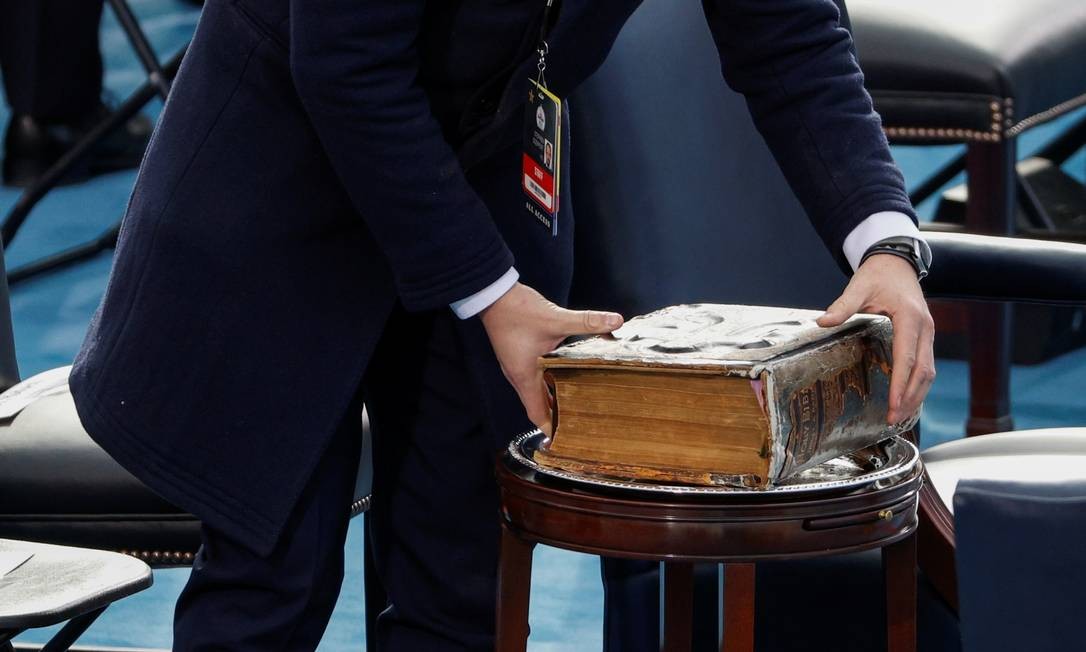 Um membro da equipe coloca a Bíblia em uma mesa antes da posse de Joe Biden Foto: BRENDAN MCDERMID / REUTERS