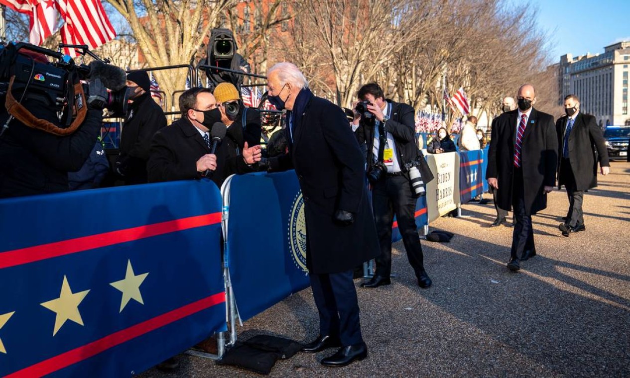 O presidente Joe Biden conversa com o repórter da NBC Mike Memoli enquanto ele caminha pela Pennsylvania Avenue em frente à Casa Branca durante as celebrações inaugurais em Washington Foto: POOL / REUTERS
