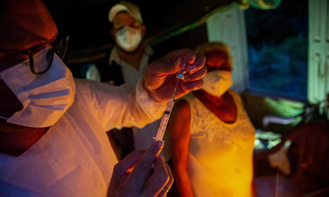 A profissional de saúde Raimunda Nonata, 70, se prepara para ser vacinada com a CoronaVac em sua casa, tornando-se a primeira quilombola imunizada no Quilombo Marajupena, no município de Cachoeira do Piriá, no Pará Foto: TARSO SARRAF / AFP - 19/01/2021