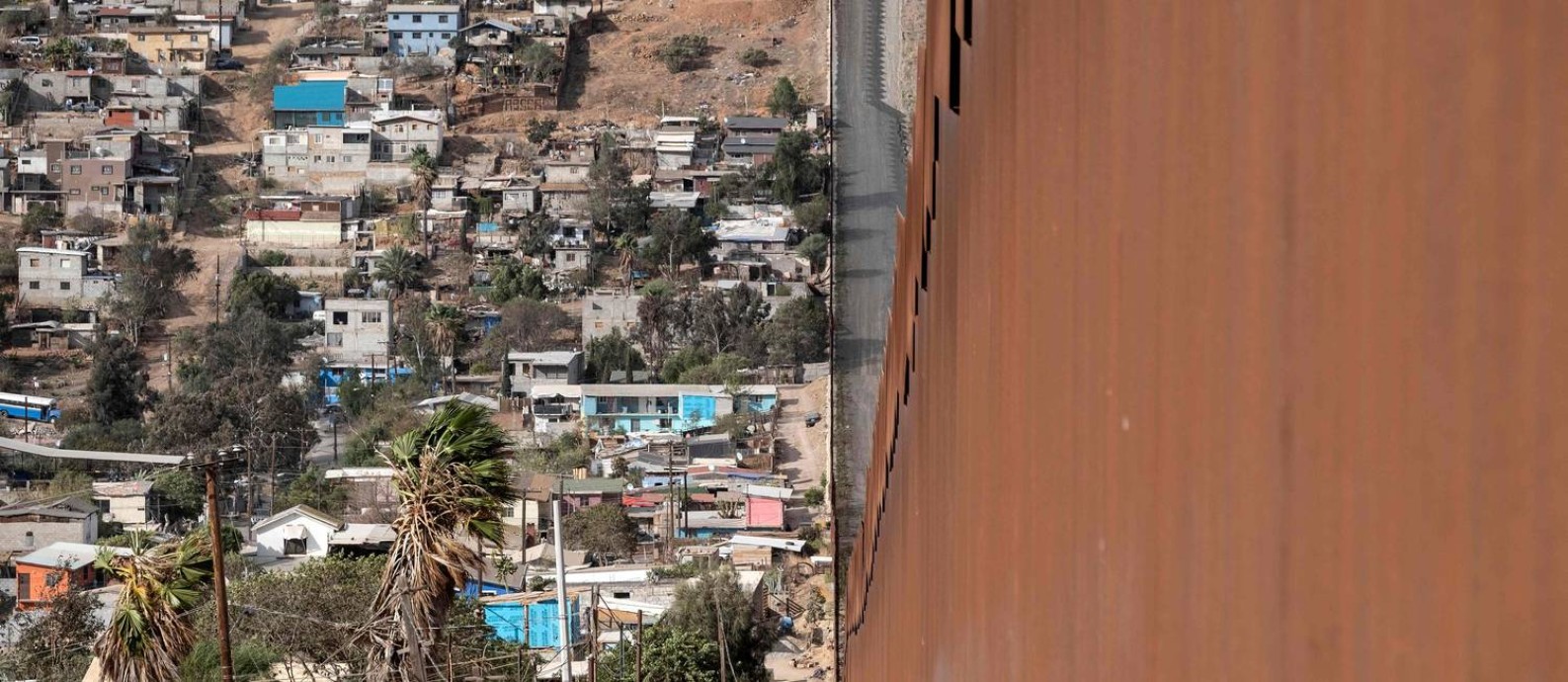 Parte do muro que marca a divisa entre os EUA e o México, perto da cidade de El Nido de las Águilas, no estado mexicano de Baja California Foto: GUILLERMO ARIAS / AFP