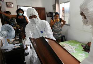Funeral directors remove the body of a Covid-19 victim, who died at her home in Manaus.  Photo: BRUNO KELLY / REUTERS