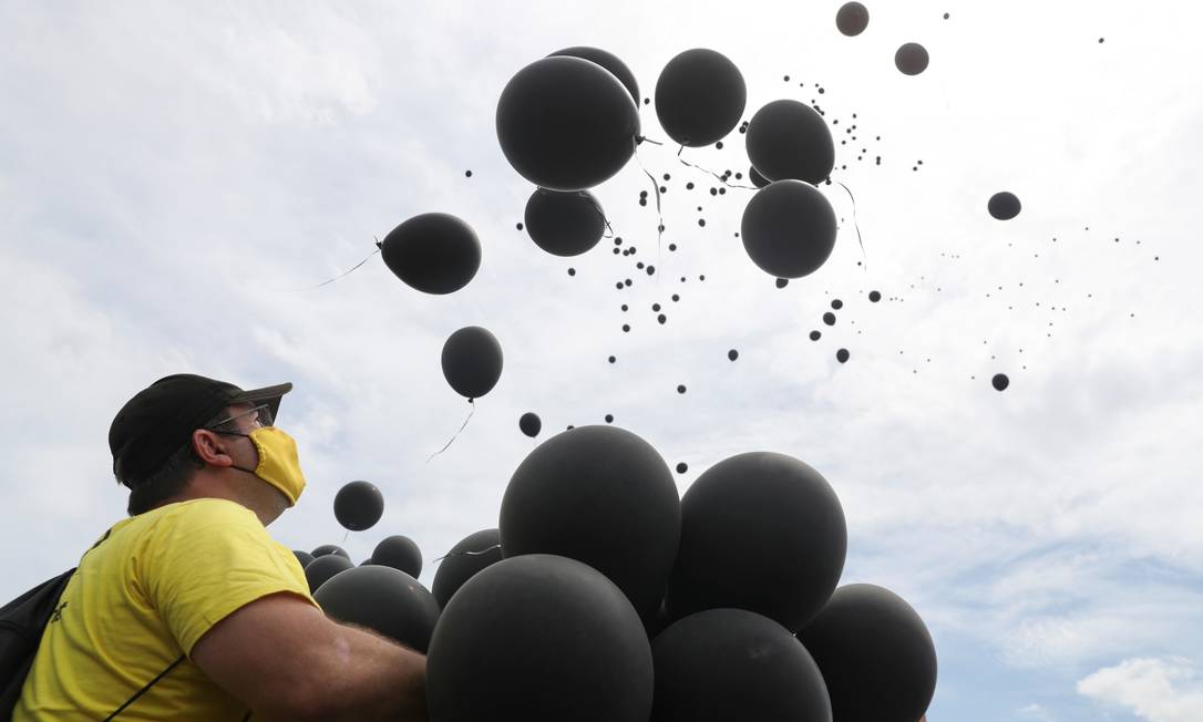 Homem solta balões em homenagem às vítimas da Covid-19 durante protesto contra o governo em São Paulo Foto: AMANDA PEROBELLI / REUTERS