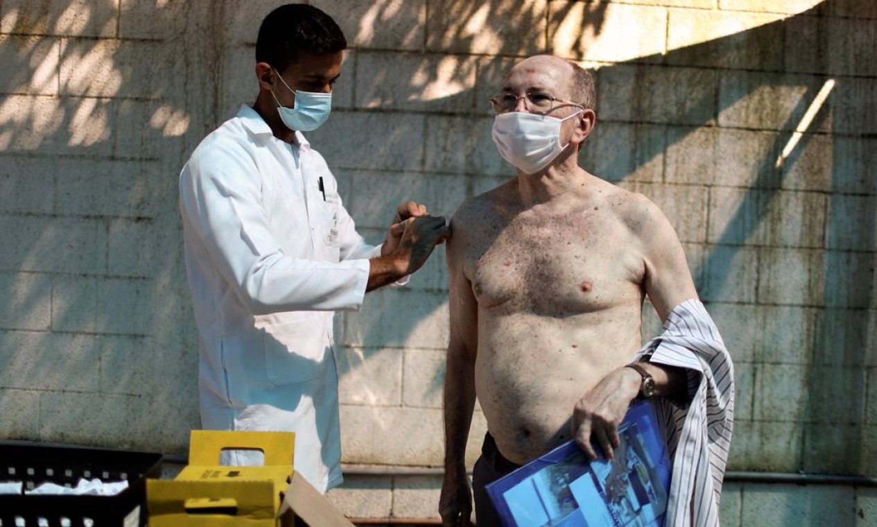 Radiologista Fernando Cesar Carvalho de Almeida, 64, recebe a AstraZeneca/Oxford, num hospital público do Rio Foto: PILAR OLIVARES / REUTERS