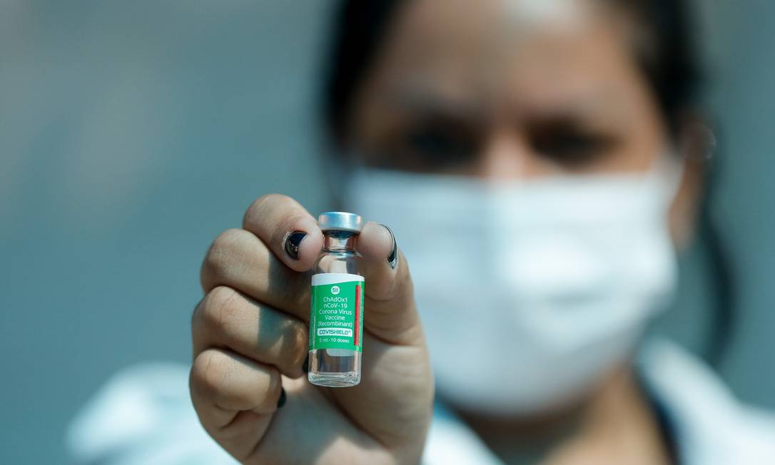Técnica de enfermagem mostra ampola de vacina contra a Covid-19 antes de aplicar a injeção Foto: Tânia Rêgo/Agência Brasil / Agência O Globo