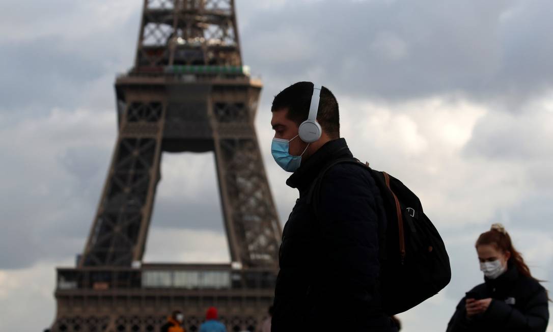 De máscara, pedestre caminha em frente à torre Eiffel Foto: GONZALO FUENTES / REUTERS / 22-1-21