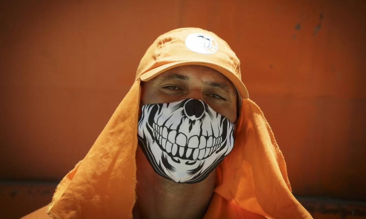 O gari Bruno Loureiro, 39 anos, conta que toma vários banhos por dia para refrescar e procura usar máscara com tecido mais fino para não sofrer tanto com o calor Foto: Márcia Foletto / Agência O Globo