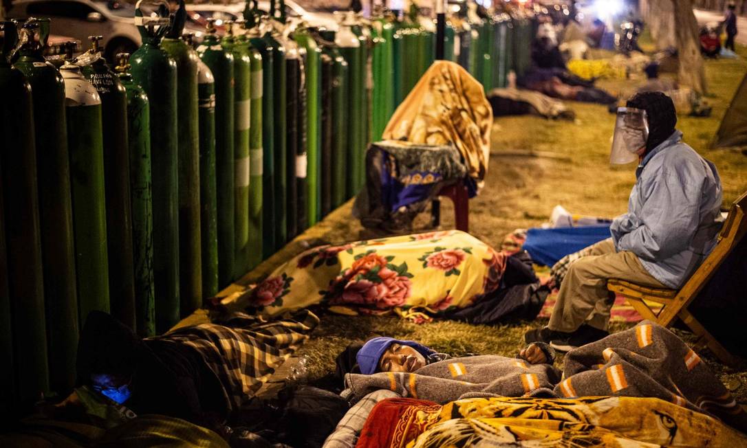 Peruanos dormem diante de cilindros vazios, em El Callao Foto: ERNESTO BENAVIDES / AFP