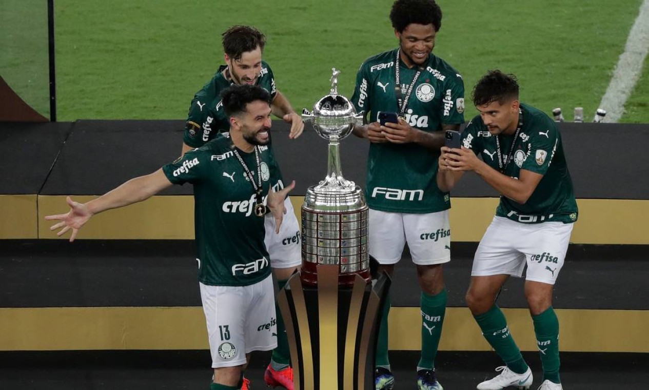Os jogadores do Palmeiras comemoram em torno do troféu após vencer a Copa Libertadores Foto: SILVIA IZQUIERDO / AFP