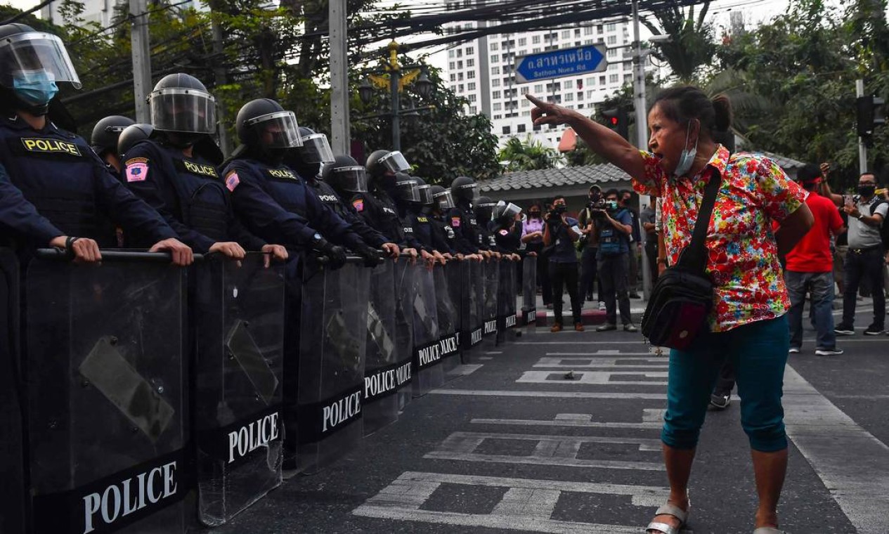 Manifestante pró-democracia tailandês enfrenta polícia em apoio ao protesto contra golpe militar no país vizinho Mianmar. Na Tailândia, também se vive ditadura militar depois de um golpe em 2014 Foto: LILLIAN SUWANRUMPHA / AFP