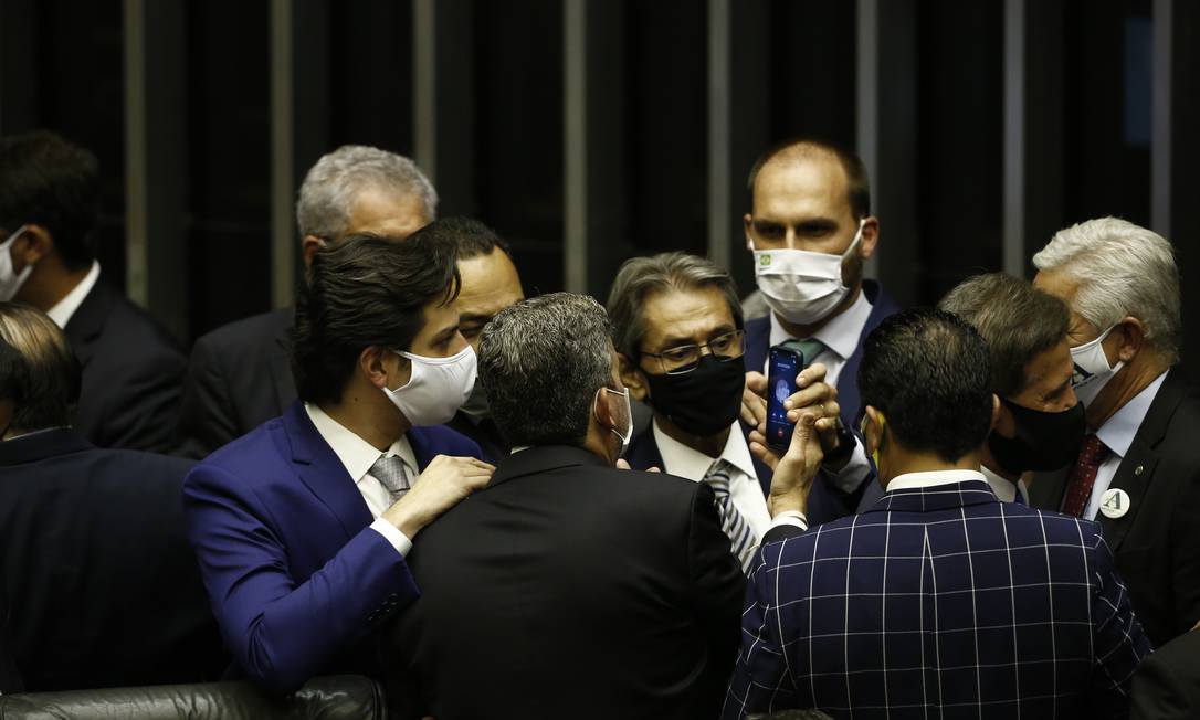 Deputado Eduardo Bolsonaro (PSL-SP) passa o telefone para o recém-eleito presidente da Câmara, Arthur Lira (PP-AL). Na tela do aparelho lê-se 