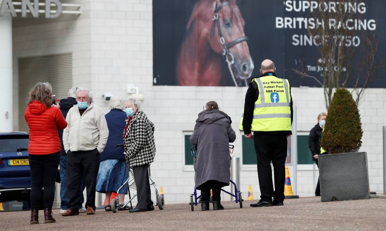 As pessoas chegam ao Epsom Downs Racecourse, na abertura como um centro de vacinação em massa, em Epsom, sul da Inglaterra Foto: ADRIAN DENNIS / AFP - 11/01/2021