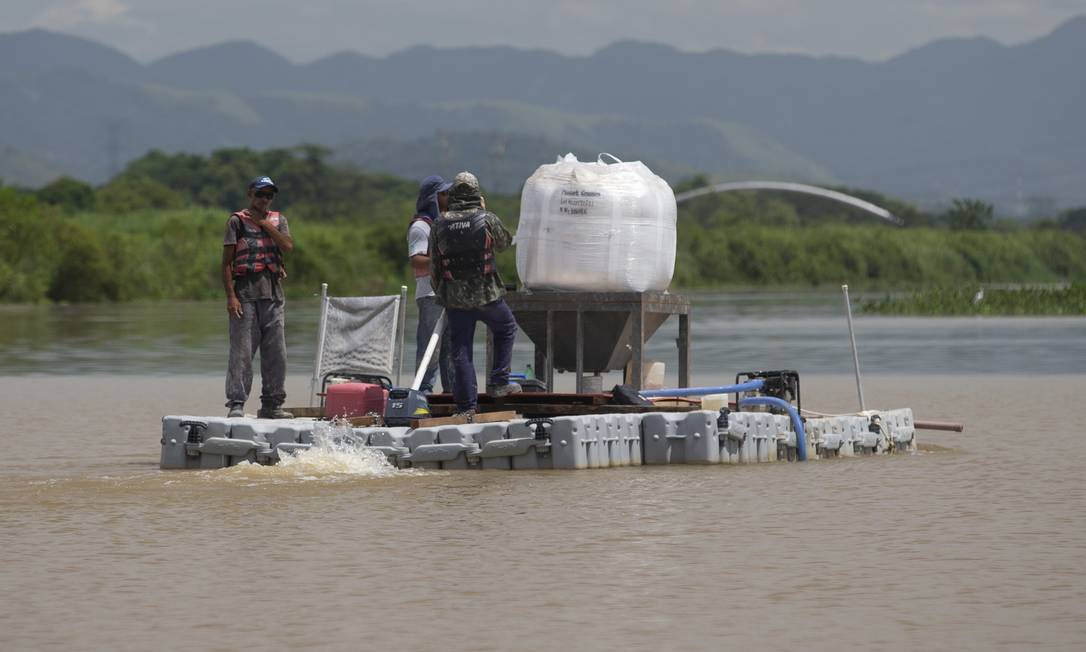 Balsa da Cedae joga produtos na água do lagoão de captação de água do Rio Guandu, em Nova Iguaçu Foto: Márcia Foletto