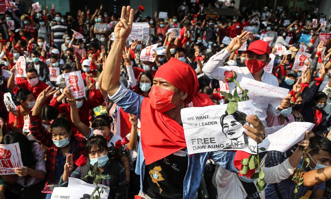 Manifestantes fazem a saudação com três dedos e seguram cartazes exigindo a libertação da líder eleita Aung San Suu Kyi enquanto participam de um protesto contra o golpe militar, em Yangon, Mianmar, 7 de fevereiro Foto: STRINGER / REUTERS