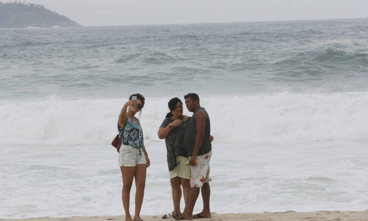 Grupo posa para selfie diante de mar ressaqueado Foto: Cléber Júnior / Agência O Globo