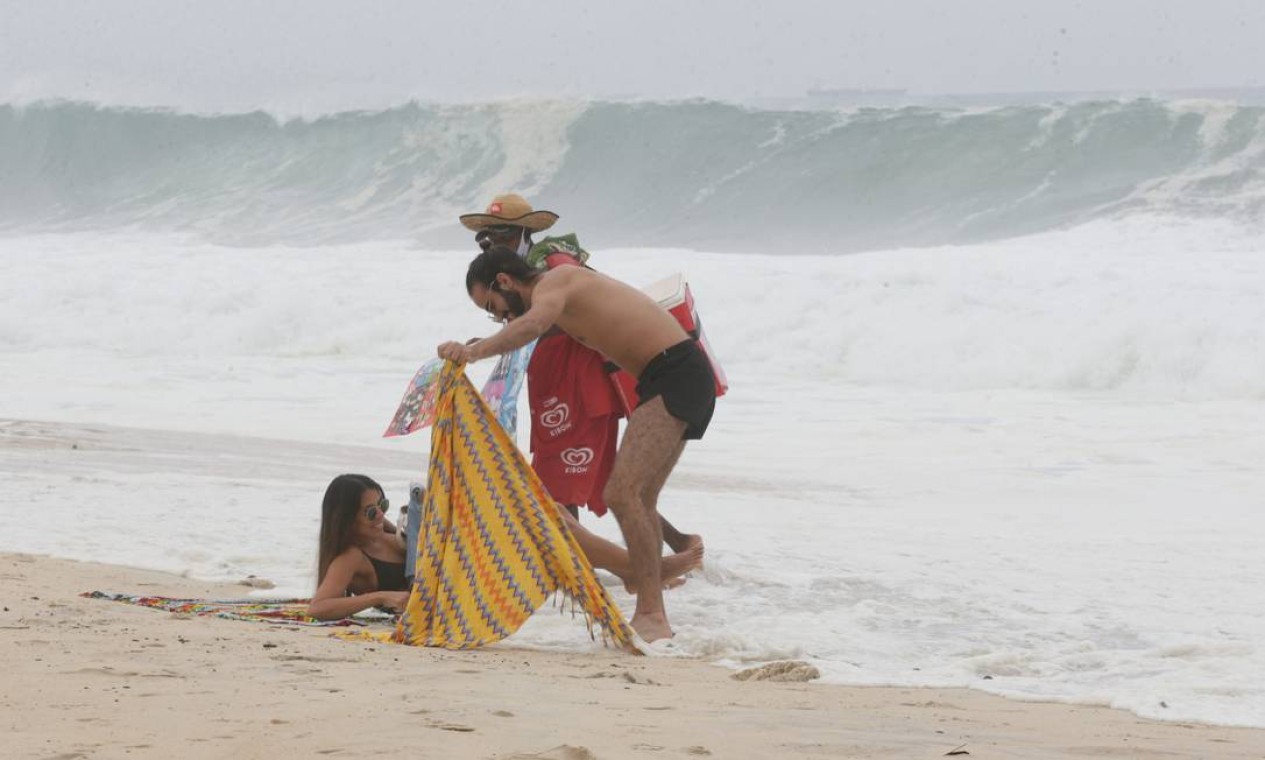 Banhistas são surpreendidos pelo mar que avança sobre pertences na areia Foto: Cléber Júnior / Agência O Globo