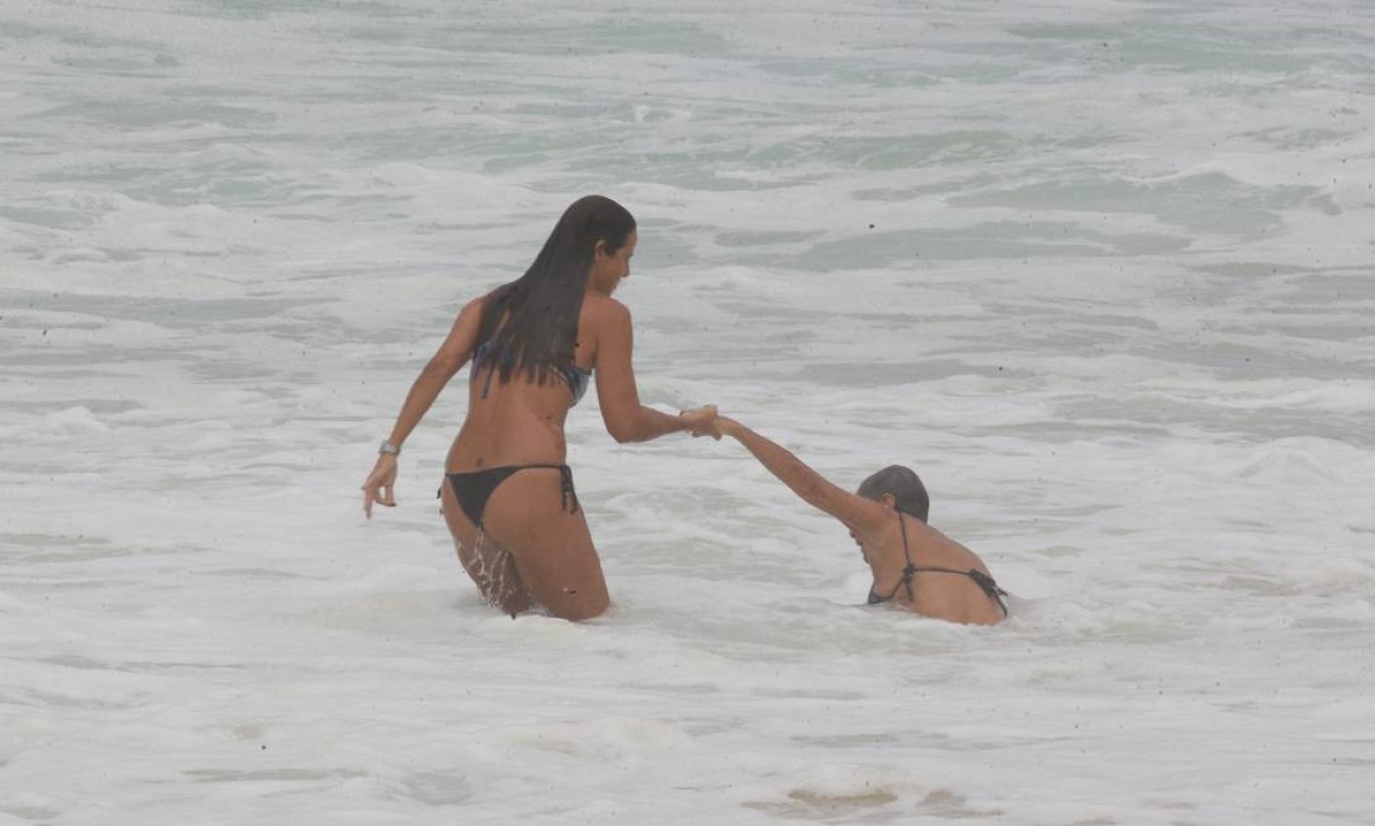 Banhista ajuda amiga derrubada por onda na praia do Leblon Foto: Cléber Júnior / Agência O Globo