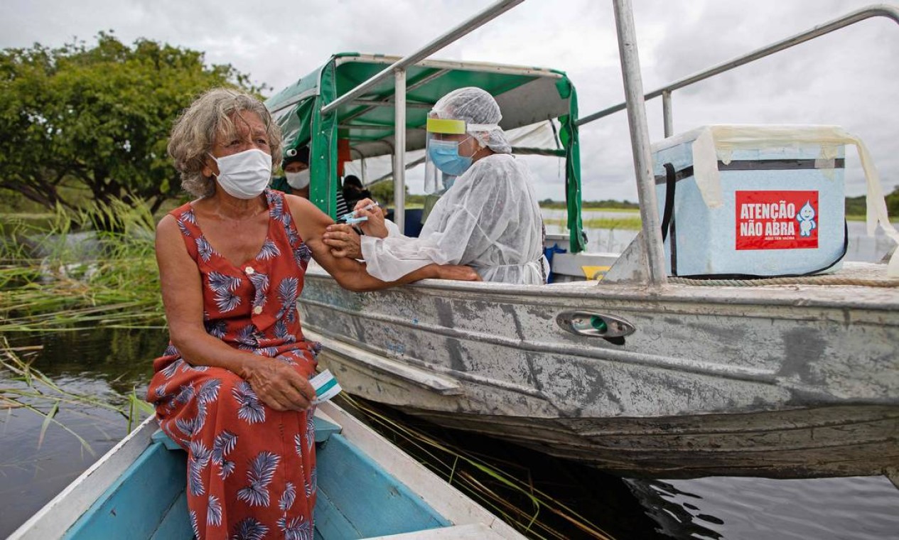 Olga D'arc Pimentel, 72 anos, é vacinada contra Covid-19, na comunidade Nossa Senhora Livramento, às margens do Rio Negro, perto de Manaus, Amazonas Foto: MICHAEL DANTAS / AFP