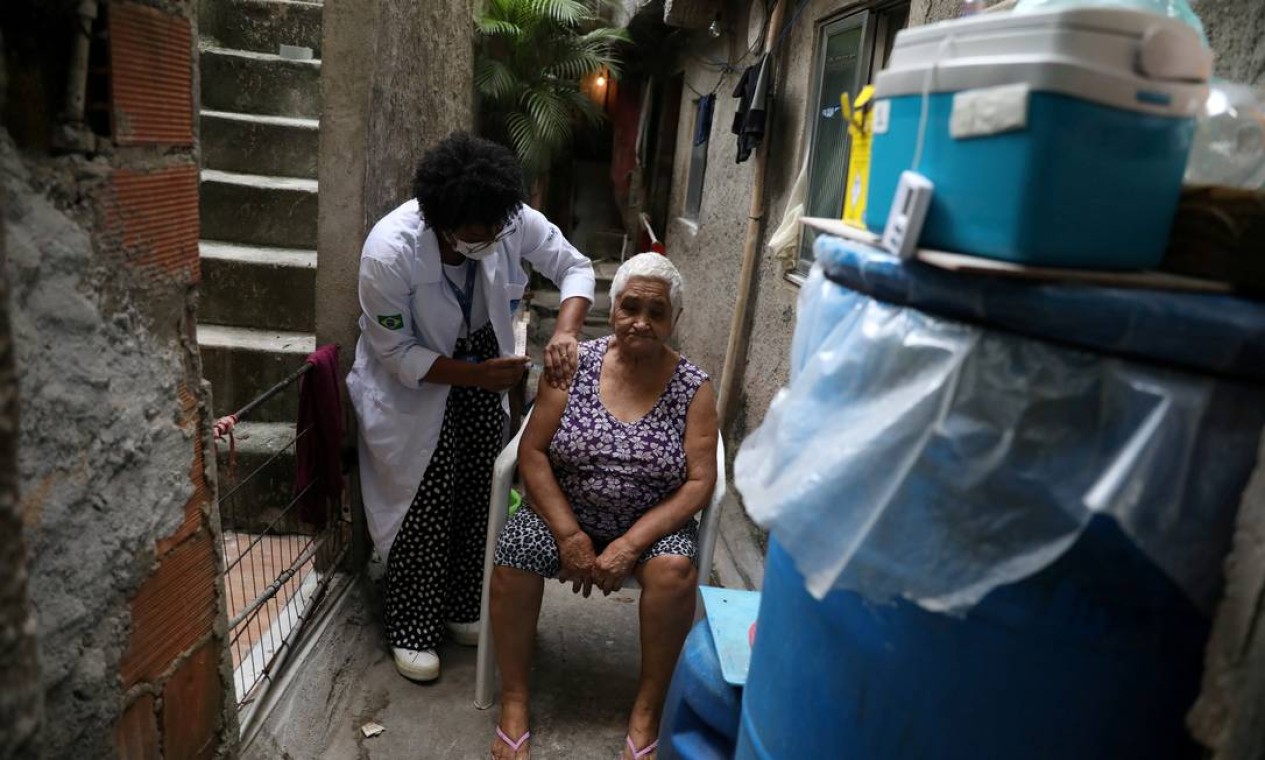 Maria do Socorro Correia, 78 anos, recebe vacina contra coronavírus em sua casa, na favela da Rocinha, no Rio de Janeiro Foto: PILAR OLIVARES / REUTERS
