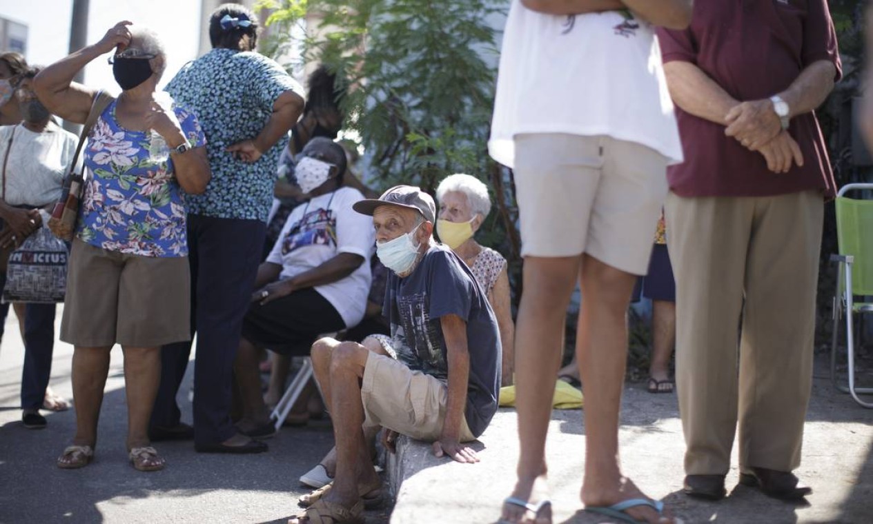Idosos acima de 93 anos esperam sentados na calçada, para receber vacina contra Covid-19 no posto Whasington Luiz Lopes, no Centro de São Gonçalo Foto: Márcia Foletto / Agência O Globo