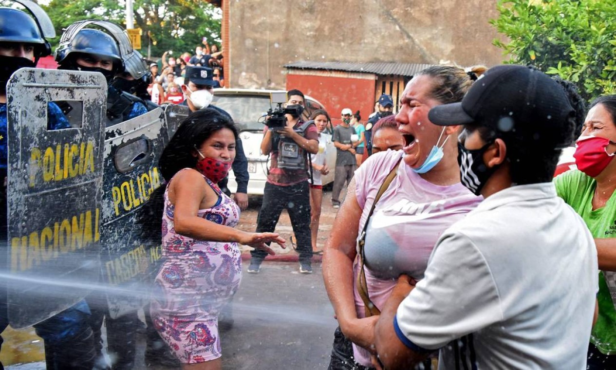Polícia confronta parentes de presidiários em frente à Cadeia de Tacumbu após rebelião que deixou seis mortos, em Assunção, Paraguai Foto: NORBERTO DUARTE / AFP