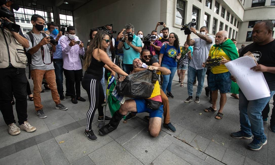 Resultado de imagem para Apoiadores de deputado preso agridem manifestante com placa de Marielle Franco na porta da PF