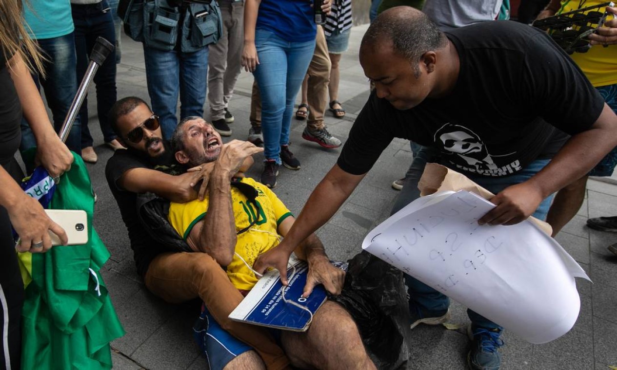Bolsonarista estrangula manifestante enquanto comparça tenta pegar a placa com em homenagem à Marielle Franco Foto: Brenno Carvalho / Agência O Globo
