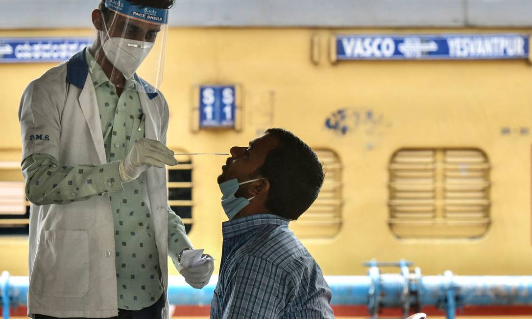Trabalhador da saúde faz teste para detectar a Covid-19 em homem, na cidade de Bangalore Foto: MANJUNATH KIRAN / AFP