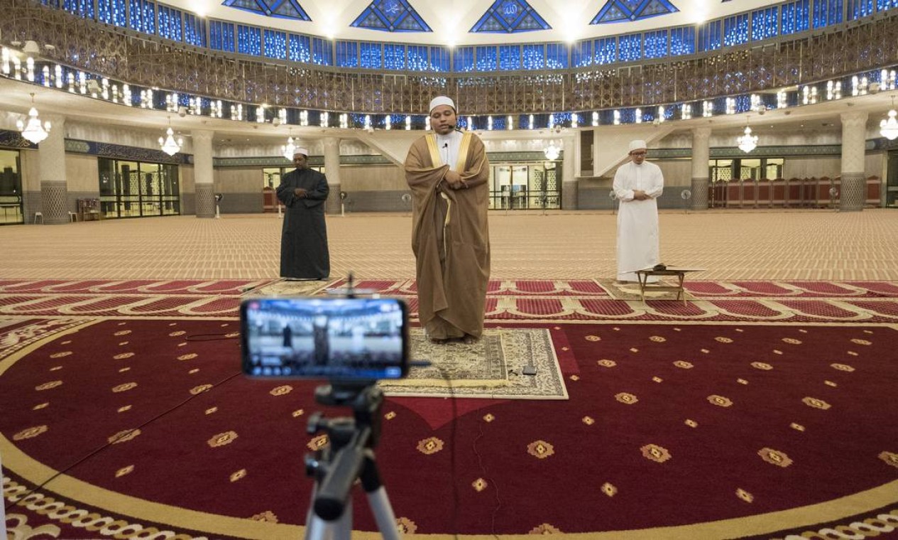 Um imã e seus assistentes realizam a oração de Tarawih na Mesquita Nacional em Kuala Lumpur, Malásia, em abril de 2020. Locais mais sagrados do Islã estavam em grande parte desertos no primeiro dia do mês sagrado do Ramadã Foto: ALEXANDRA RADU / The New York Times