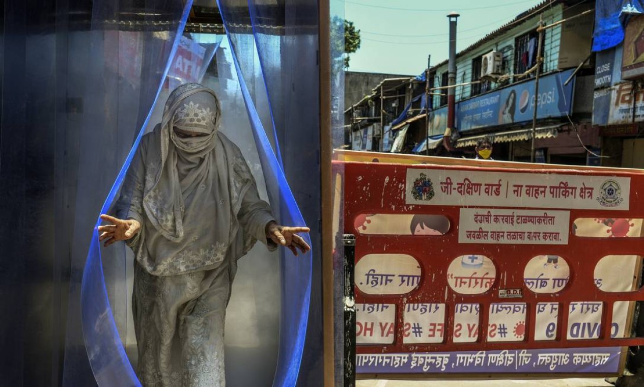 Mulher passa por um túnel de desinfecção em Mumbai, em abril de 2020. Cidade de 20 milhões de habitantes é agora responsável por 20% das infecções por coronavírus na Índia e quase 25% das mortes Foto: ATUL LOKE / The New York Times
