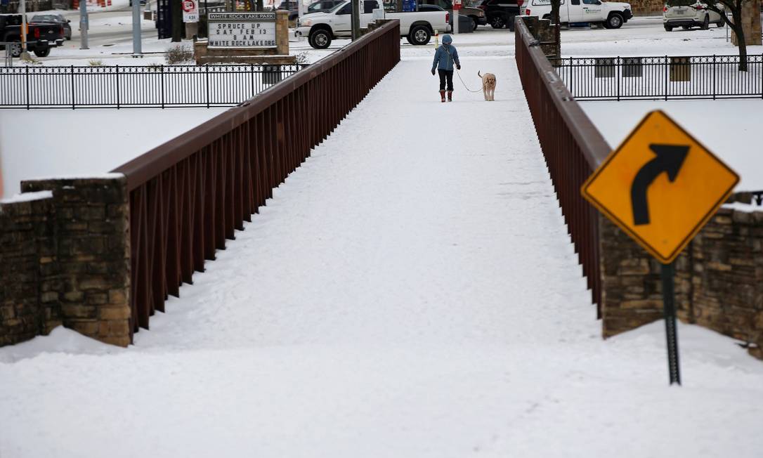 Mulher caminha com seu cachorro em meio à neve em Dallas, no Texas Foto: BRANDON WADE / REUTERS