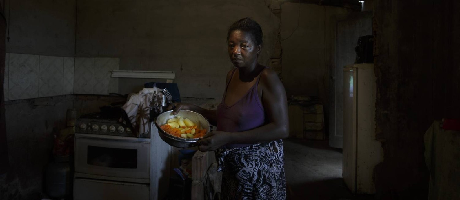 Simone Souza Bernardes, 49 anos, mostra os legumes que ganhou de um vizinho: jantar será a única refeição da família no dia Foto: Márcia Foletto / Agência O Globo