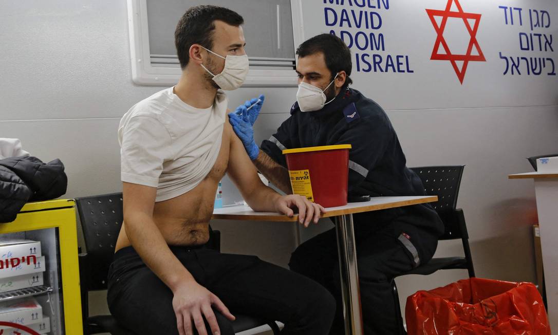 Profissional de saúde administra vacina contra Covid-19 em Tel Aviv Foto: GIL COHEN-MAGEN / AFP