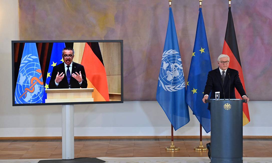O diretor-geral da OMS, Tedros Adhanom Ghebreyesus (à esquerda, na TV) participa de videoconferência com o presidente da Alemanha, Frank-Walter Steinmeier, nesta segunda-feira (22) Foto: JOHN MACDOUGALL / AFP