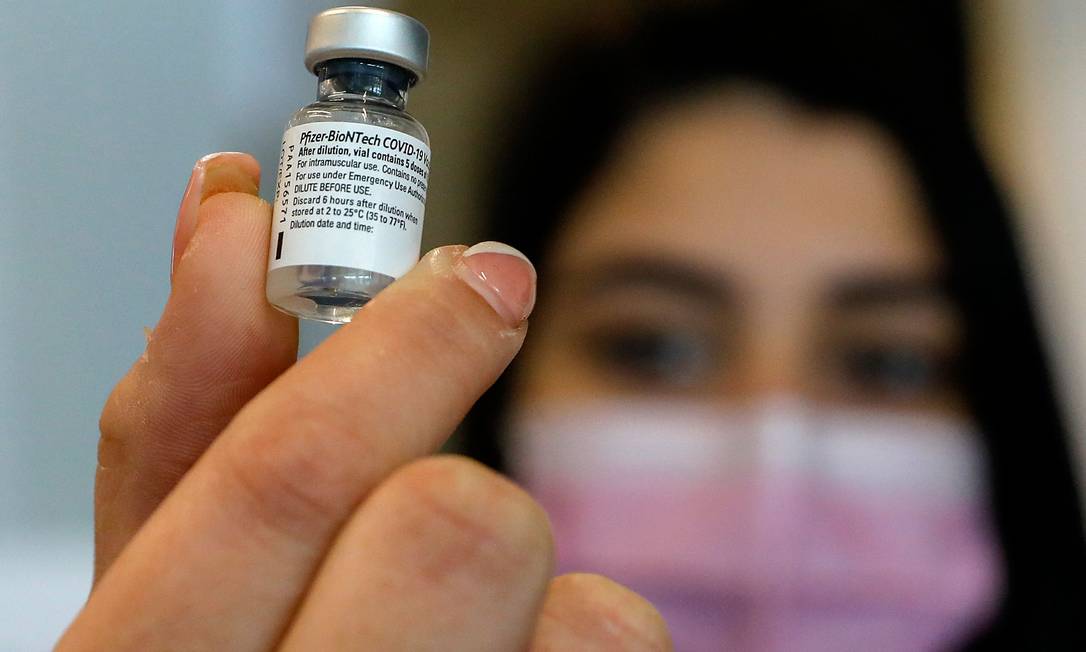 Profissional de saúde segura frasco com vacina contra Covid-19 da Pfizer-BioNTech, em Israel Foto: AHMAD GHARABLI / AFP