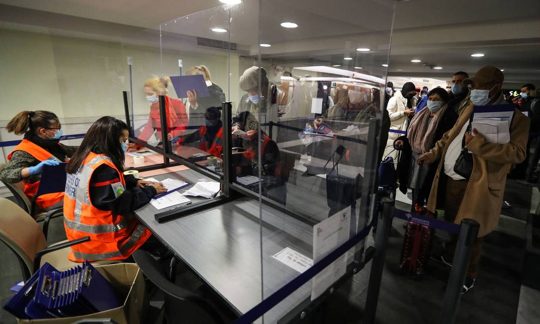Passageiros mostram documento a oficiais de segurança franceses no aeroporto de Nice, após serem testados Foto: VALERY HACHE / AFP