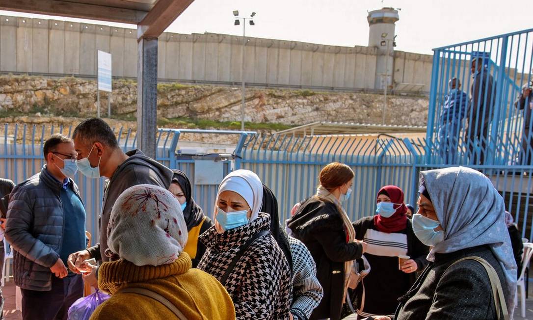 Palestinos aguardam para serem vacinados em um posto de controle entre a cidade de Ramallah, na Cisjordânia, e Jerusalém Oriental Foto: Ahmad Gharabli /AFP 