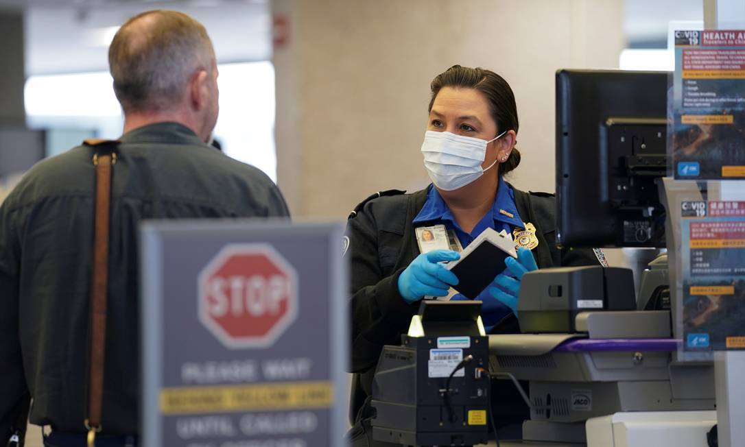 Mulher confere passaporte no aeroporto de Dulles, nos arredores de Washington. Foto: KEVIN LAMARQUE / REUTERS