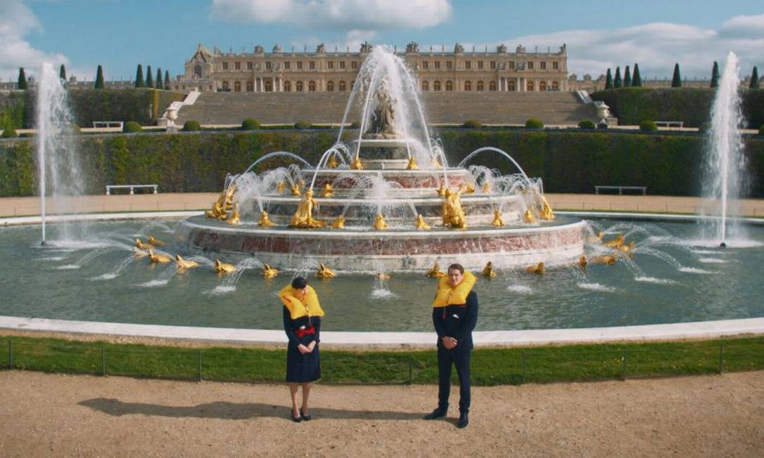 Comissários de bordo em frente às fontes do Palácio de Versailles, nos arredores de Paris, em cena do novo vídeo de segurança de voo da Air France Foto: Air France / Divulgação