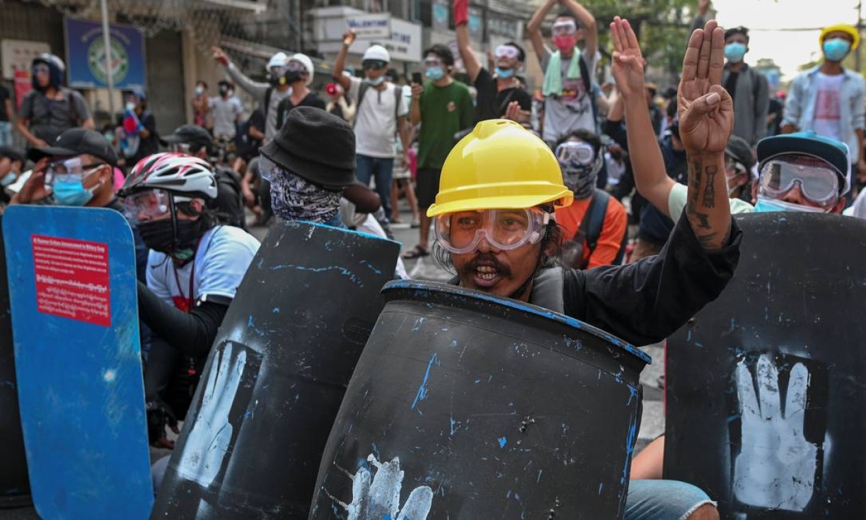 Galões de plástico usados como escudo e EPI da construção civil são usados para se proteger das forças repressoras do golpe militar Foto: STRINGER / REUTERS - 27/02/2021